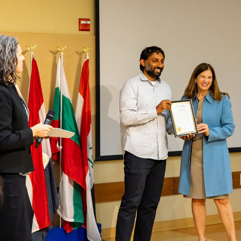 Younus Mirza, left, receives award from SU president, Tracy Fitzsimmons