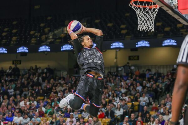 A Harlem Globetrotters player soars for a two-handed dunk.