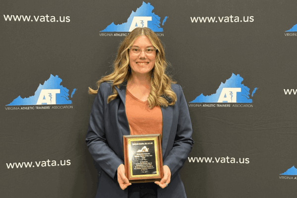 Mackenzie Enterline holds a plaque for the VATA Secondary Athletic Trainer of the Year award