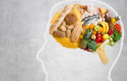 Stock photo showing a head outlined, with photos of various foods arranged in the brain area, to reflect how diet affects the mind.