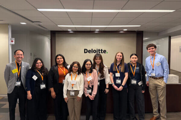 Accounting students and faculty pose for a photograph in one of Deloitte's offices.