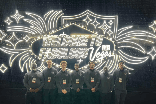 Members of the men's basketball team in front of a Las Vegas sign.