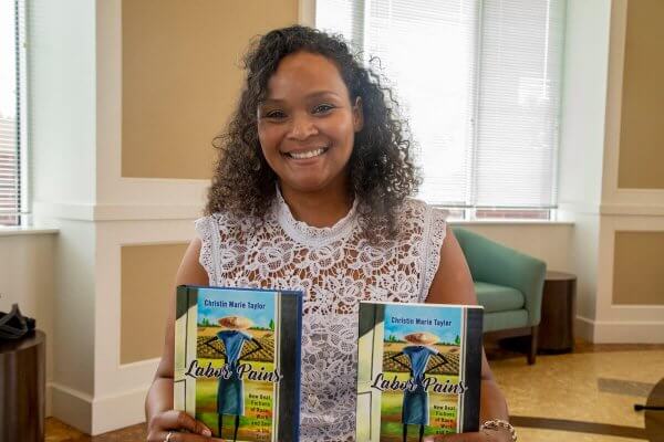 Shenandoah University Assistant Professor of English Christin Taylor, Ph.D., with her book "Labor Pains."