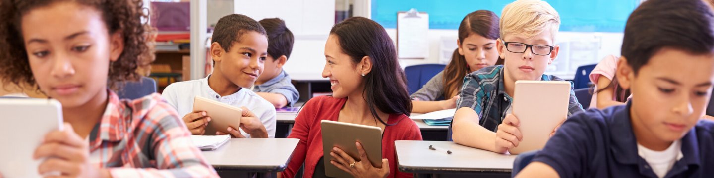 Smiling teacher assists students in classroom