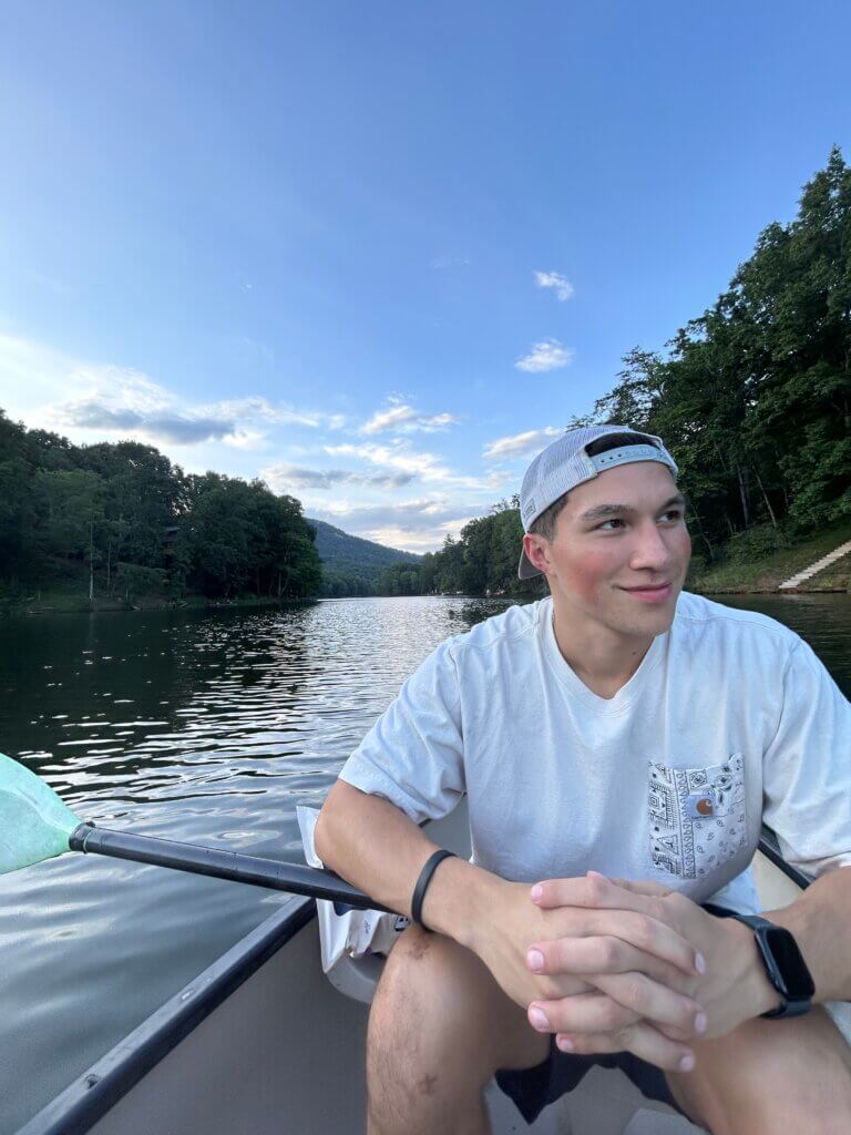 Andrew Quach ’26 | Health and Physical Education major | Kinesiology minor, in a boat on a creek or river