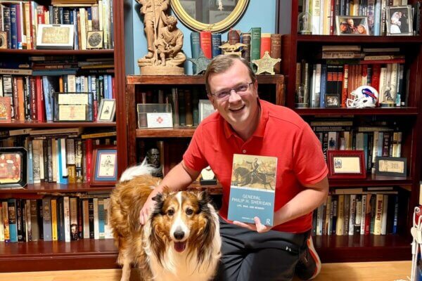 Jonathan Noyalas poses with his new book and his dog, Mr. Lincoln.