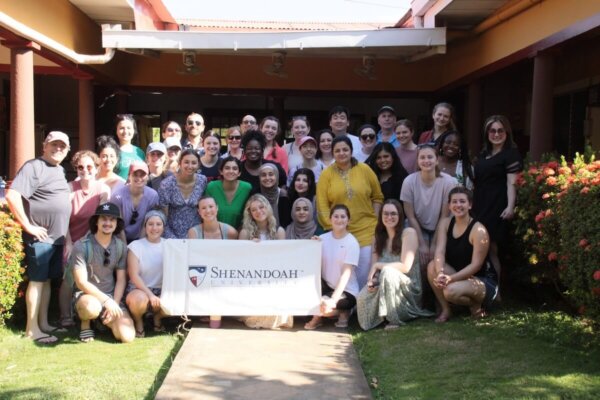 Shenandoah health professions and pharmacy students and faculty gathered around a Shenandoah banner in Nicaragua in 2024.