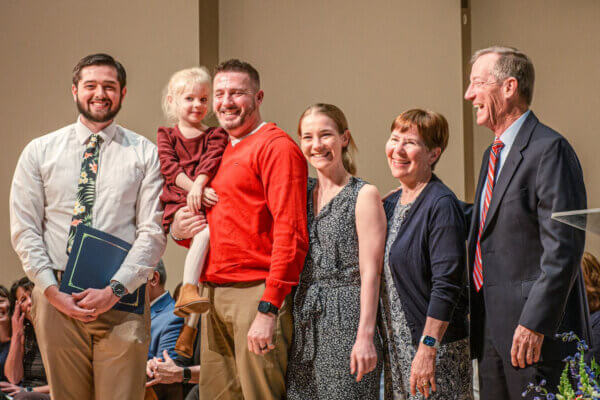 The family of Kelly McGaughey Roseberry joins Shenandoah University physical therapy student Ryan McGinniss for a photo.