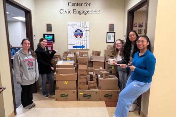 Center for Civic Engagement student staffers with food drive donations in October 2025.