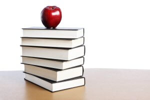 Stock photo of apple on top of books for story about Shenandoah education graduate student Sujin Chung winning VACTE scholarship.