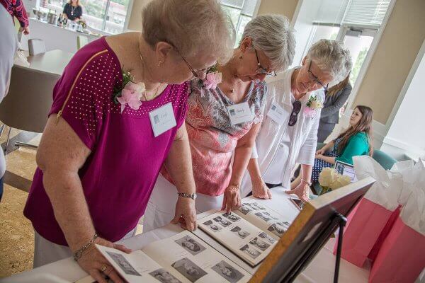 Members of Shenandoah University's nursing class of 1967 look at old photos at their 50th reunion