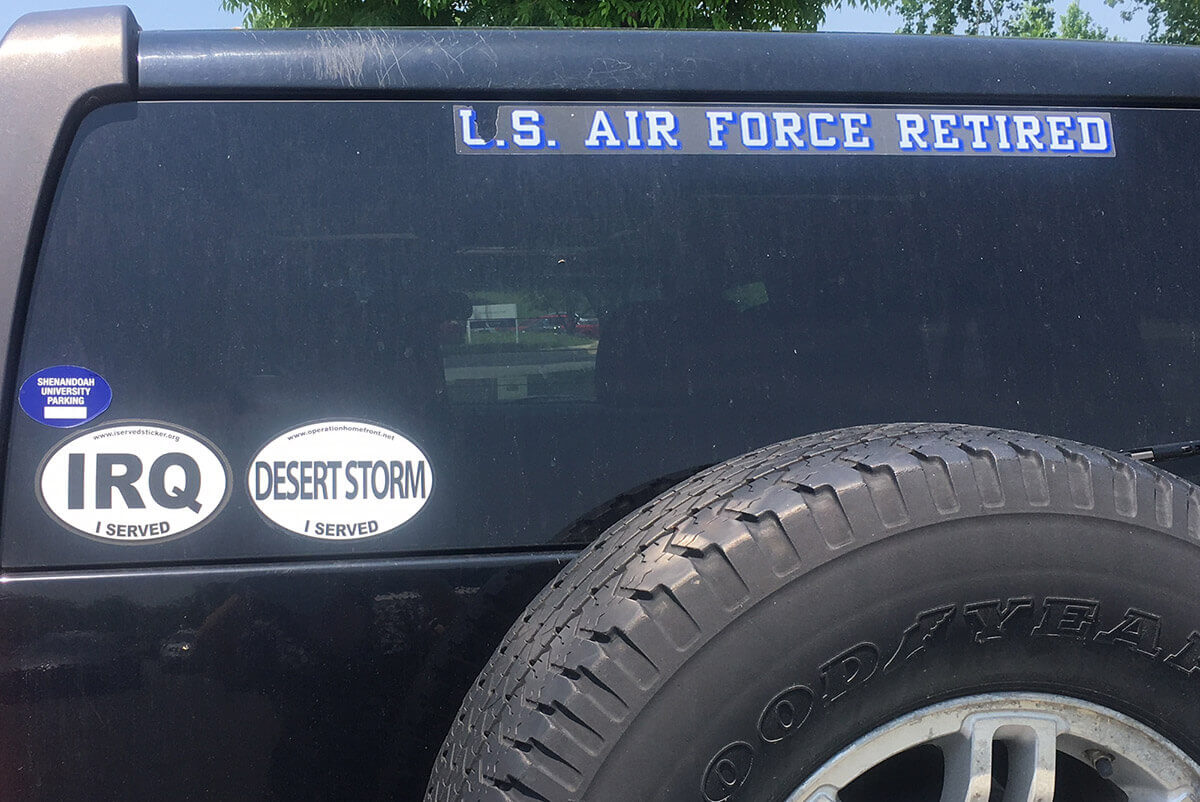 Vehicle parked at Shenandoah University military expo. Vehicle features Shenandoah sticker, US Air Force Retired transparency, and IRQ and Desert Storm magnets.