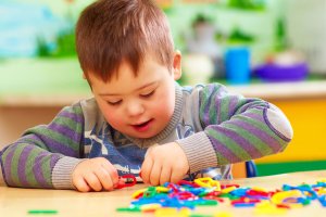 Child with down's syndrome playing in kindergarten