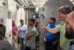 Shenandoah University business students learn about sustainable practices at Gat Creek Furniture's boiler room.