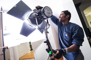 Shenandoah University student Orlando Levins adjusts lighting during a commercial feature film shoot.