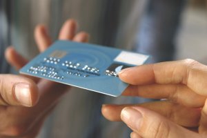 Image of credit card passed from hand to hand.