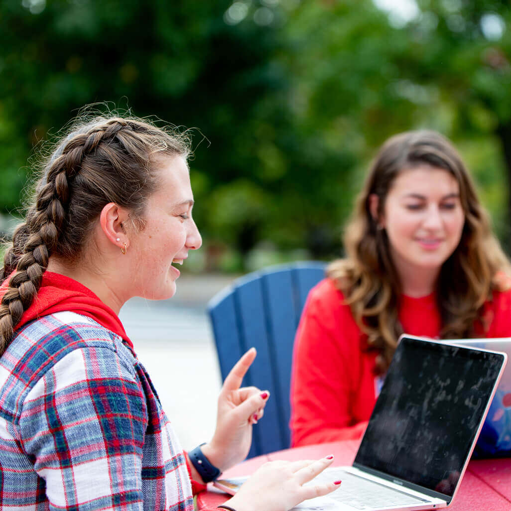 Students at outside table working online