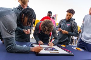 Shenandoah University students sign a thank you gift for the Vaden family