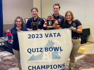 Shenandoah University athletic training students Chloe Tannenbaum, Molly Sobolewski, Cade Watts and Meghan Flaherty pose with the tropy and banner after winning the 2023 Virginia Athletic Trainers' Association (VATA) Quiz Bowl at the VATA Annual Meeting in Harrisonburg, Virginia, on Jan. 13-15.
