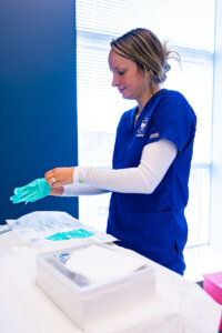 A Shenandoah University nursing student puts on medical gloves