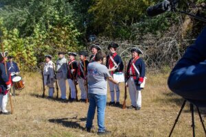 Shenandoah student Joey Miciotta holds a clap board in front of a line of members from the National Society of the Sons of the American Revolution during the filming of training videos for the SAR