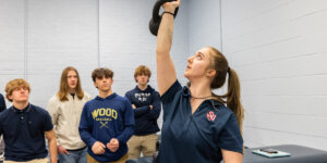 A Shenandoah University MSAT student demonstrating kettle bell exercises to visiting high school students