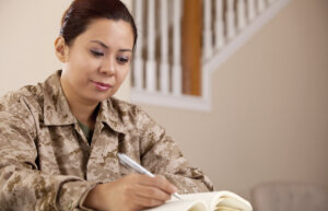 US Marine Female Soldier Working/Looking at book. The model is wearing an official Marine uniform (MARPAT).