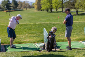 An adaptive athlete swings a golf club during the First Swing Seminar and Learn to Golf Clinic