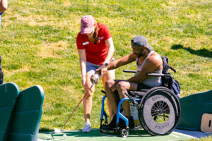 A Shenandoah University physical therapy student works with an adaptive athlete during the First Swing Seminar and Learn to Golf Clinic