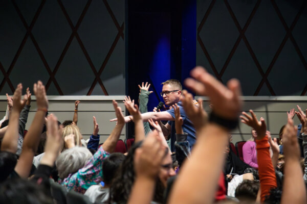 Hands raised around Mr. Schu at the Rally for Reading at Shenandoah University on May 11, 2023. 