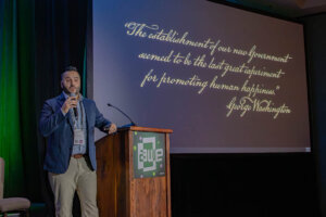 Shenandoah University Director of Augmented Reality/Virtual Reality (B.S.) and Co-Director of the Shenandoah Center for Immersive Learning (SCiL) Mohammad Obeid speaks at a podium during the Augmented World Expo in California