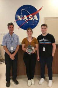 Shenandoah Director of Applied Technology Ralph Wojtowicz and students Shannon Eissele and Connor Hill pose with the payload they constructed at NASA's RockOn workshop