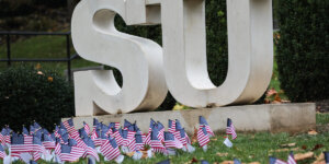 SU statue in Shenandoah University main campus Quad, surrounded by small U.S. flags. Photo by Caleb Rouse.