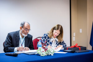 Dr. Yaqub Mirza and Tracy Fitzsimmons, Ph.D., sign agreements related to funding for the Barzinji Institute for Global Virtual Learning.
