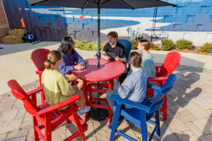 A group of students having a conversation at a table on the Brandt Student Center patio