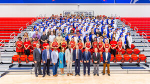 Shenandoah University Marching Band, cheerleaders, Studio Big Band and university leadership on bleachers and court at Wilkins Athletics & Events Center for announcement of the group's invitation to London's New Year's Day Parade 2025. 