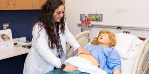 A Shenandoah University nurse midwifery student works with a manikin in a simulation lab