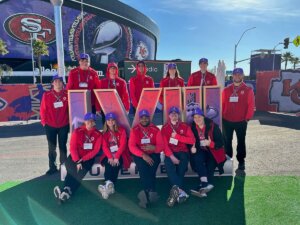 Shenandoah University students pose with the Super Bowl LVIII logo in front of Allegiant Stadium in Las Vegas.