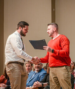 Shenandoah University physical therapy student Ryan McGinniss receives the Kelly McGaughey Roseberry PT Service Award from Chris Roseberry.