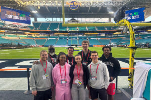 Shenandoah University students and staff pose for a photo on the field at Hard Rock Stadium.