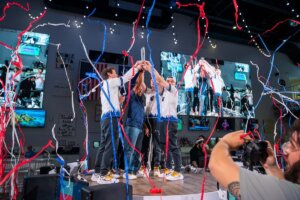 WVU's esports team celebrates winning the 2024 Boost on the Beach event as streamers fall.