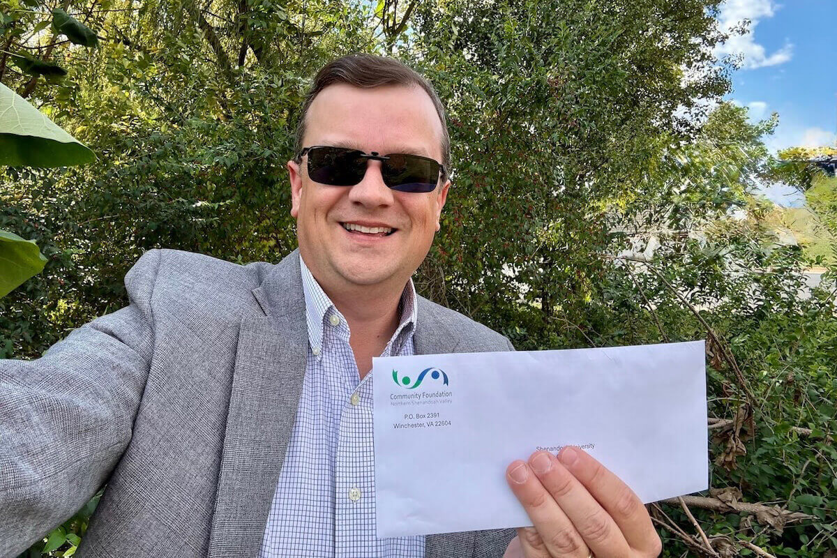 Jonathan Noyalas holds an envelope containing a check for a grant from the CFNSV's Boxley-Fox Endowment Fund.