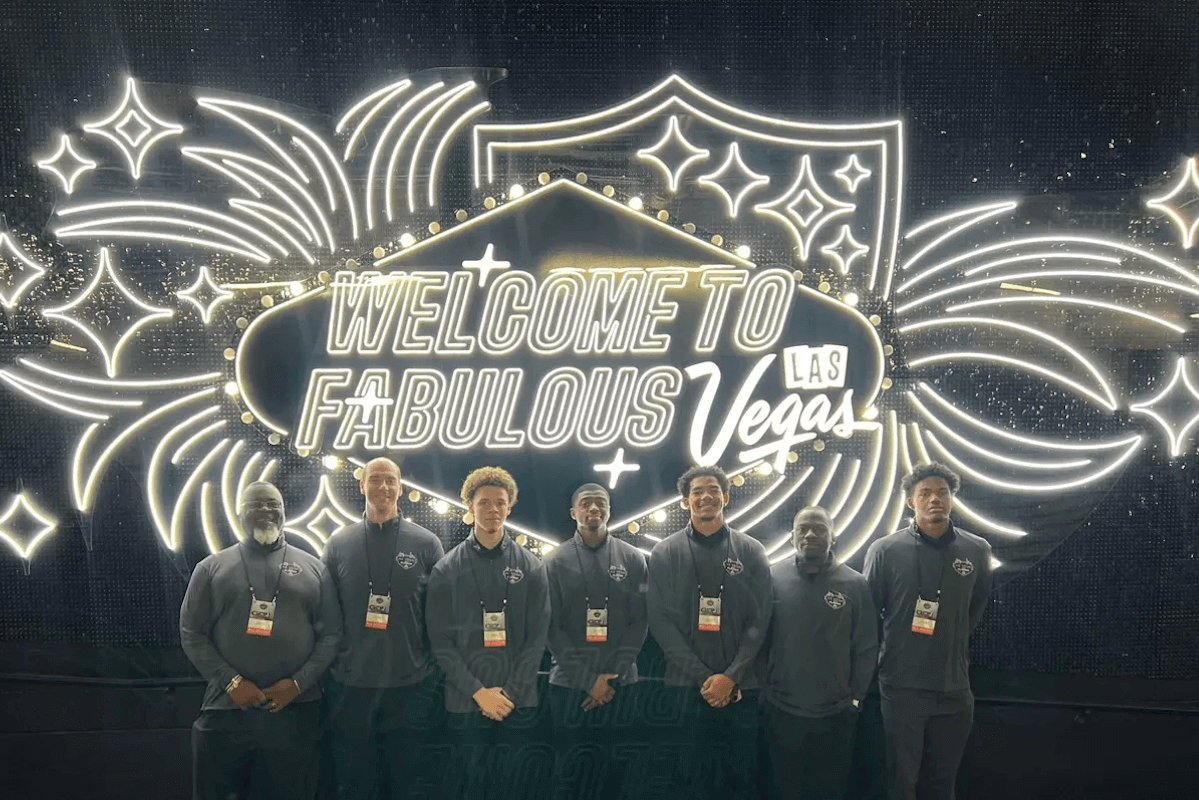 Members of the men's basketball team in front of a Las Vegas sign.