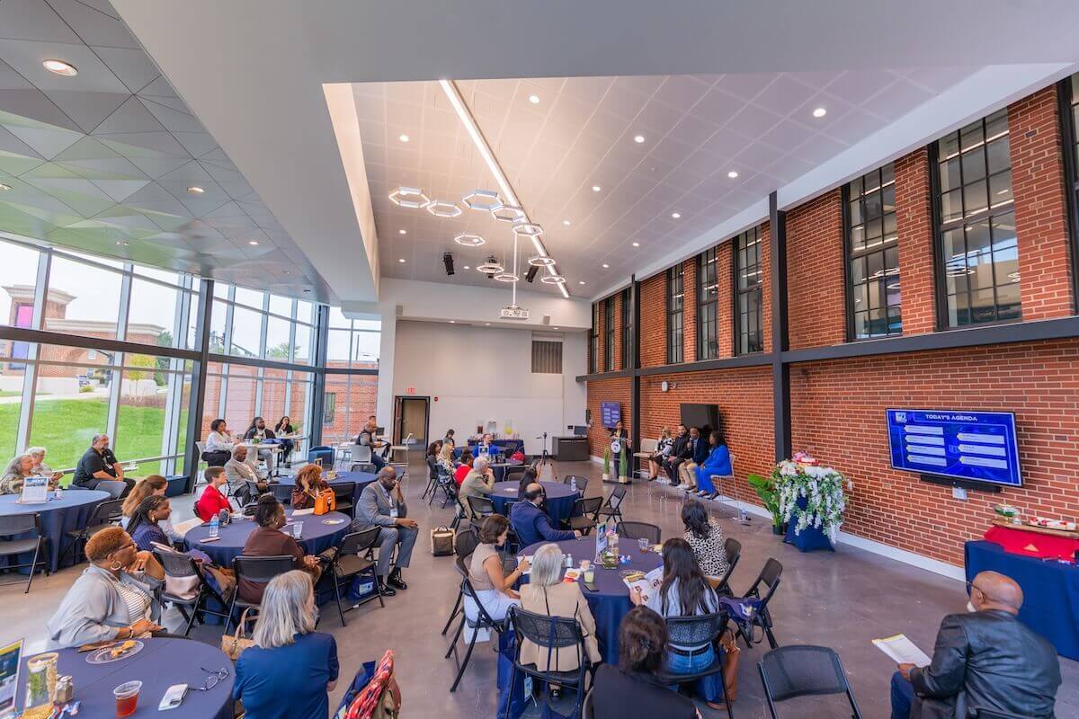 People are seated at tables in the Hazel-Pruitt Armory, Collaboratory.