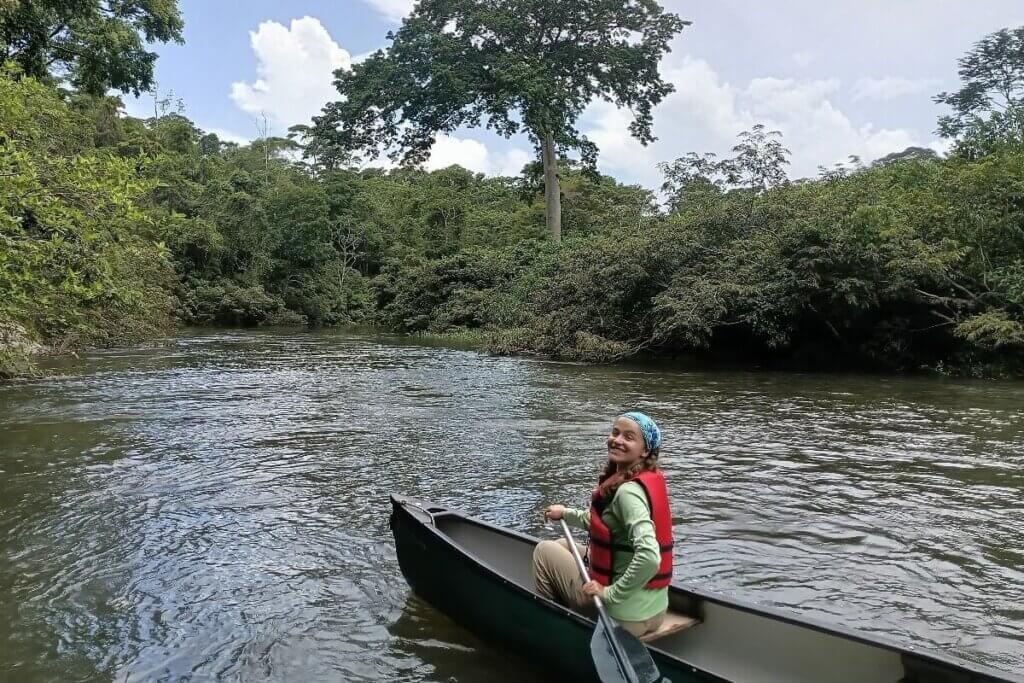 Shenandoah University student Sophie Koutalakis ’26 rowing a canoe on a river in Belize.