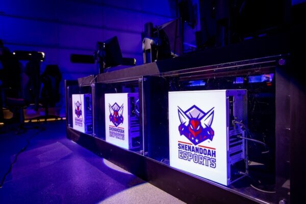 Gaming computers lined up in the Esports Arena featuring Shenandoah's esports logo.