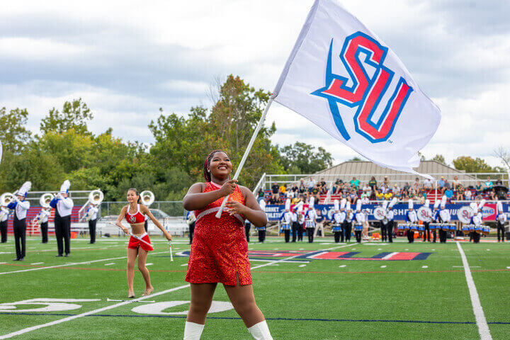 Jess Yorke spins her flag on Glo Fiber Field at Shentel Stadium.