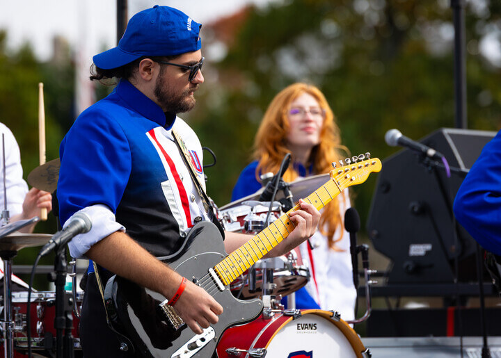 Jose Rivas plays his guitar on the marching band's rock band trailer.