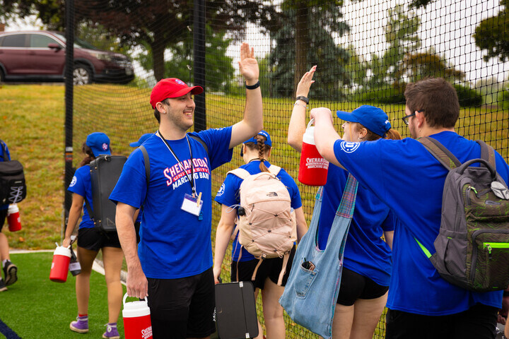 Drum Major Josh Prior gives high-fives to other students at summer band camp.