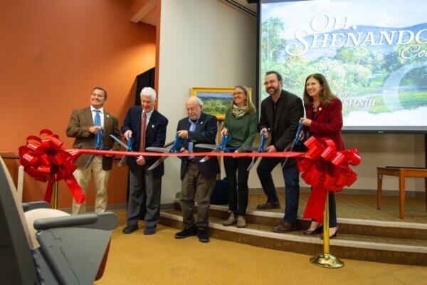 Individuals cut a ribbon celebrating the opening of the Andrei Kushnir Collection in Halpin-Harrison Hall.